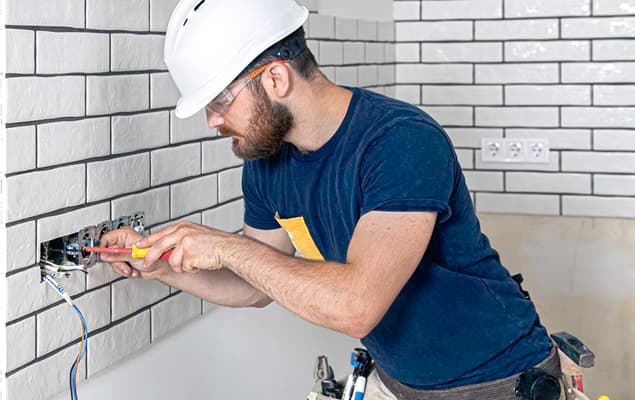 Electrician installing a wall socket during a home renovation
