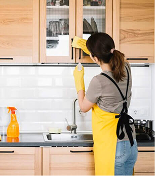 Cleaner wiping kitchen cabinets