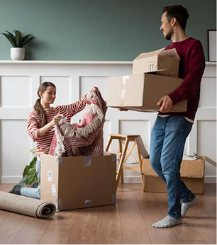 Couple moving boxes into new home